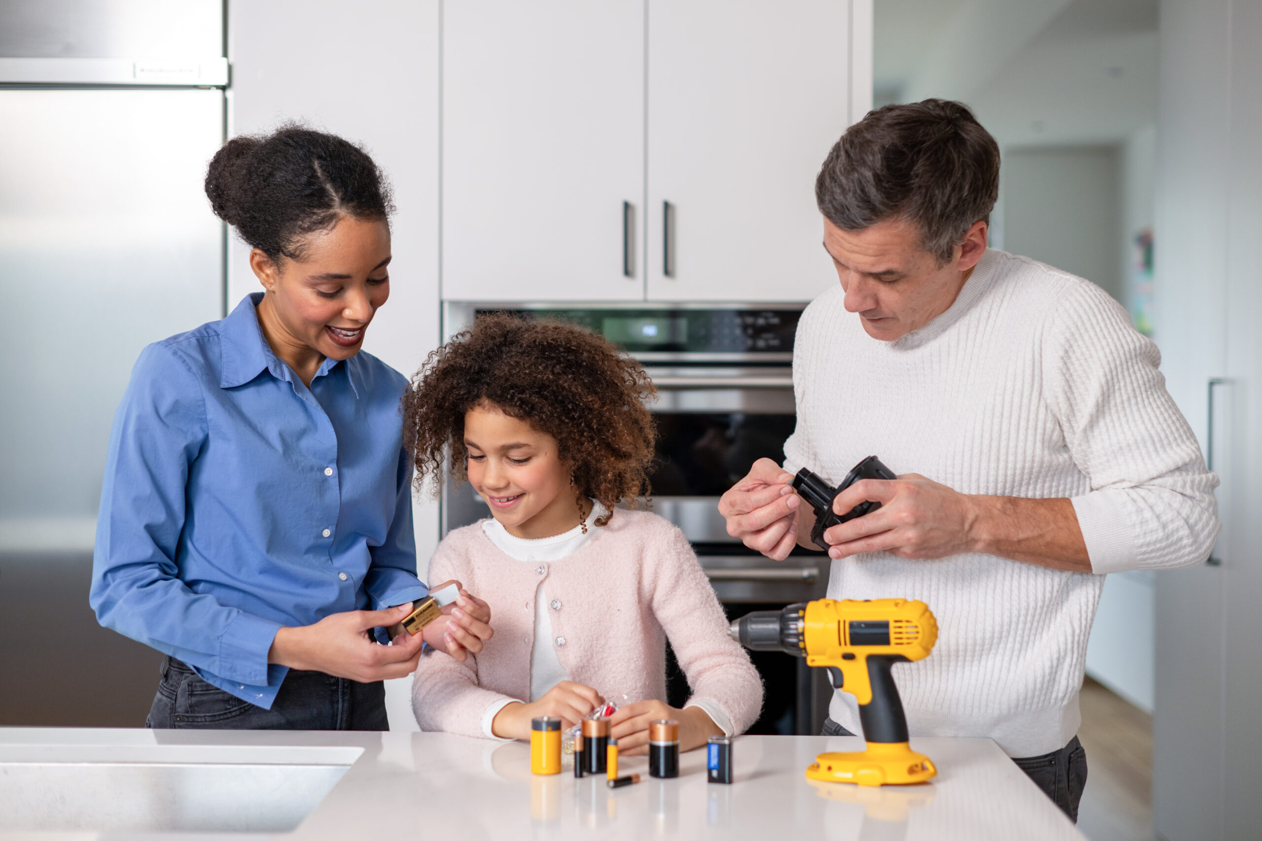 Papa, maman et fille protégeant des piles et batteries